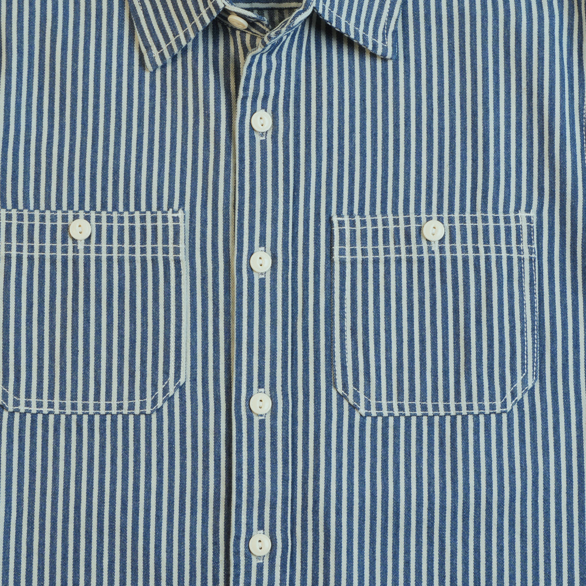 Two buttoned chest patch pockets with contrast stitching on the hickory stripe cotton work shirt.